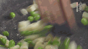 鍋中油7成熱時(shí)，入青豆、筍丁翻炒，然后加糯米飯加鹽均勻翻炒。