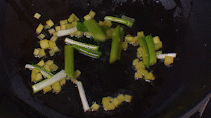 鍋中熱油，依次下姜粒、蔥段、蘆筍炒香。