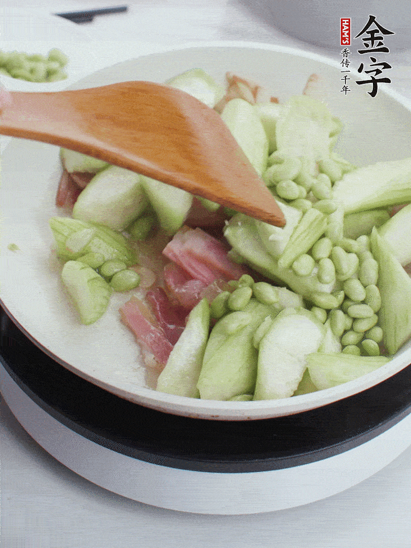 依次下絲瓜、青豆翻炒，炒至絲瓜打蔫縮小。