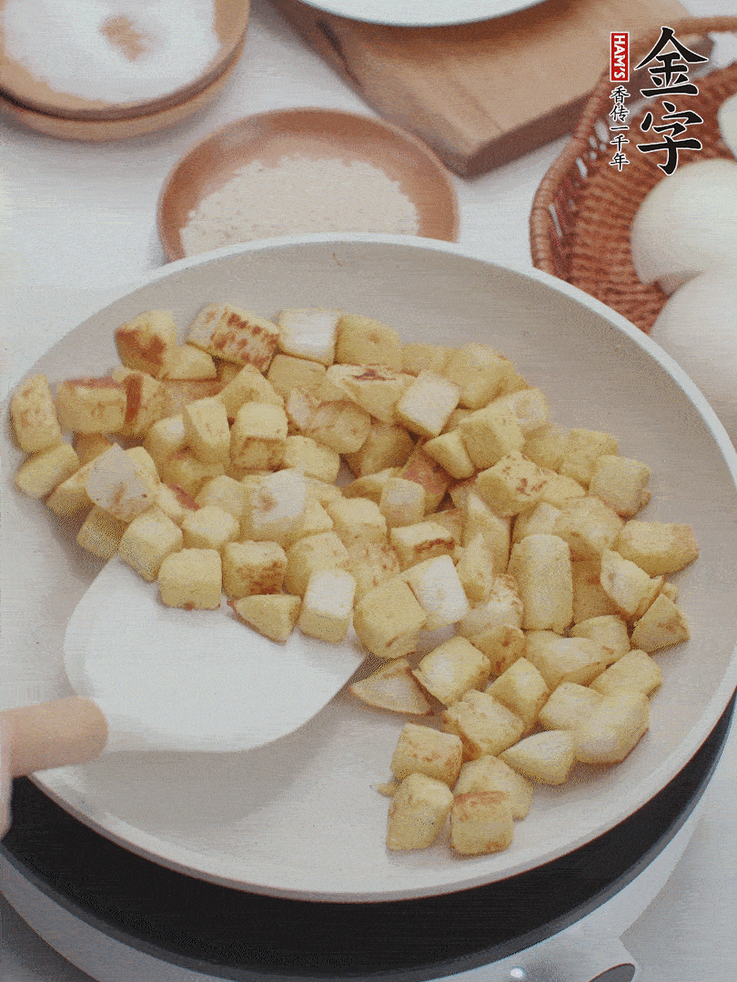 起鍋熱油，倒入饅頭丁，小火煎至蛋液凝固定型再翻面，饅頭丁部煎至金黃時盛起待用。