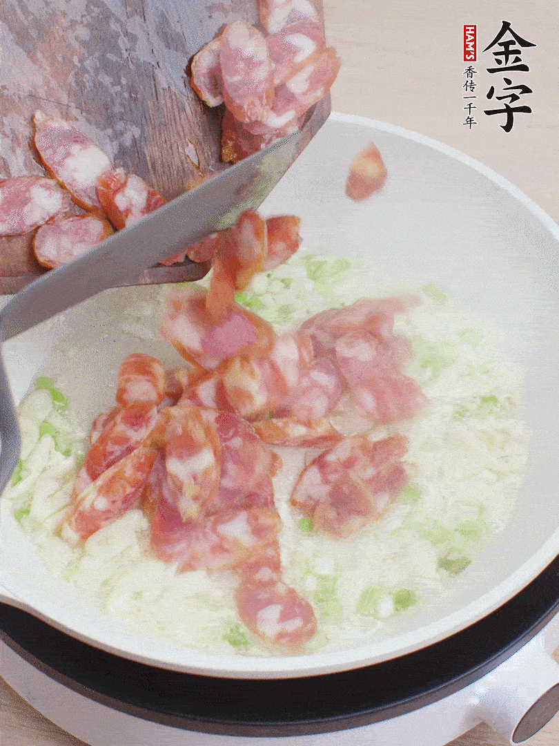 油5成熱，蒜末、蔥白爆香，下香腸炒出香味。