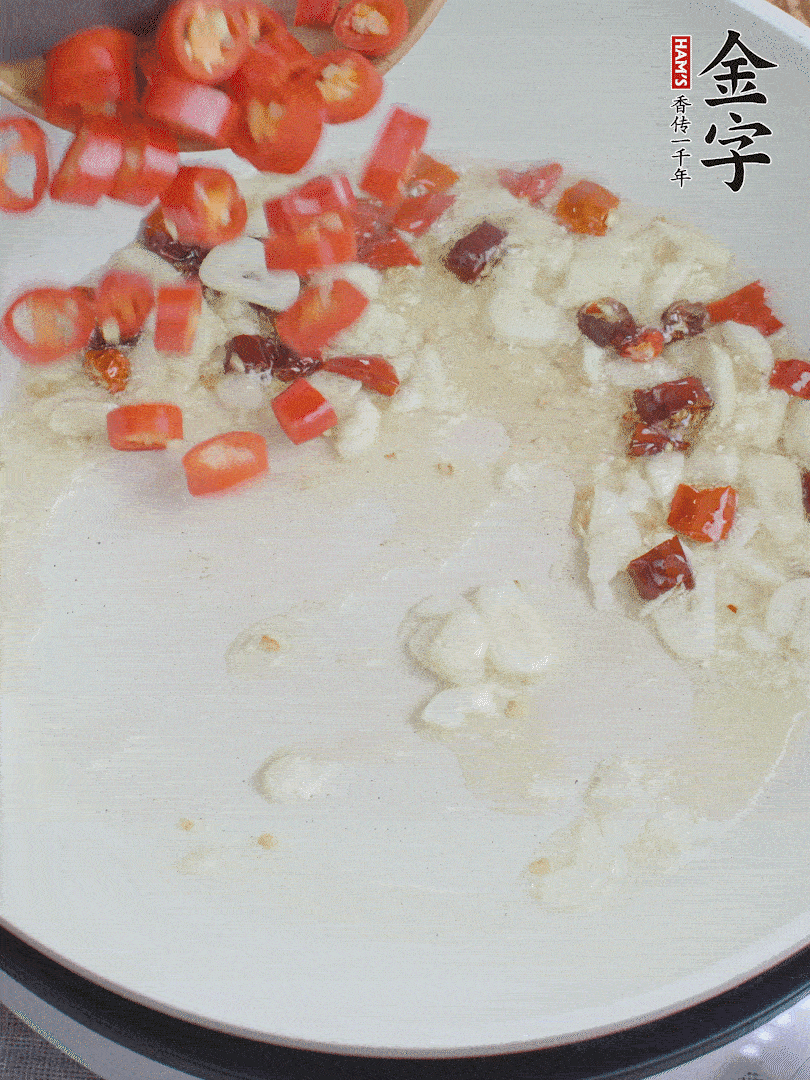 油6成熱，下蒜末、干紅辣椒煸炒，出香味后再放美人椒、香腸。