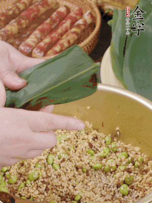 粽葉往下折，完全蓋住，兩側(cè)捏緊。