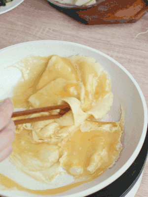 油6成熱時(shí)，下雞蛋液，邊緣凝固時(shí)翻拌成塊狀。