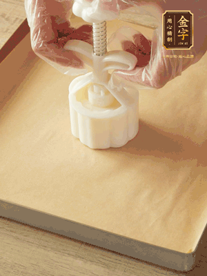 取一個(gè)面團(tuán)，捏扁，中間厚，四周薄。虎口往上推，直到收口，把餅胚放入模具里，壓2-3下