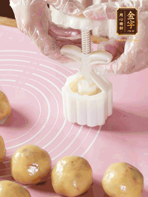 收緊虎口搓圓，裹上一層面粉，放入模具壓一壓